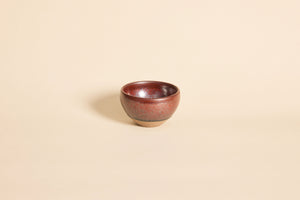 Dark red Tenmoku Jianzhan tea cup with subtle flowing ember patterns
