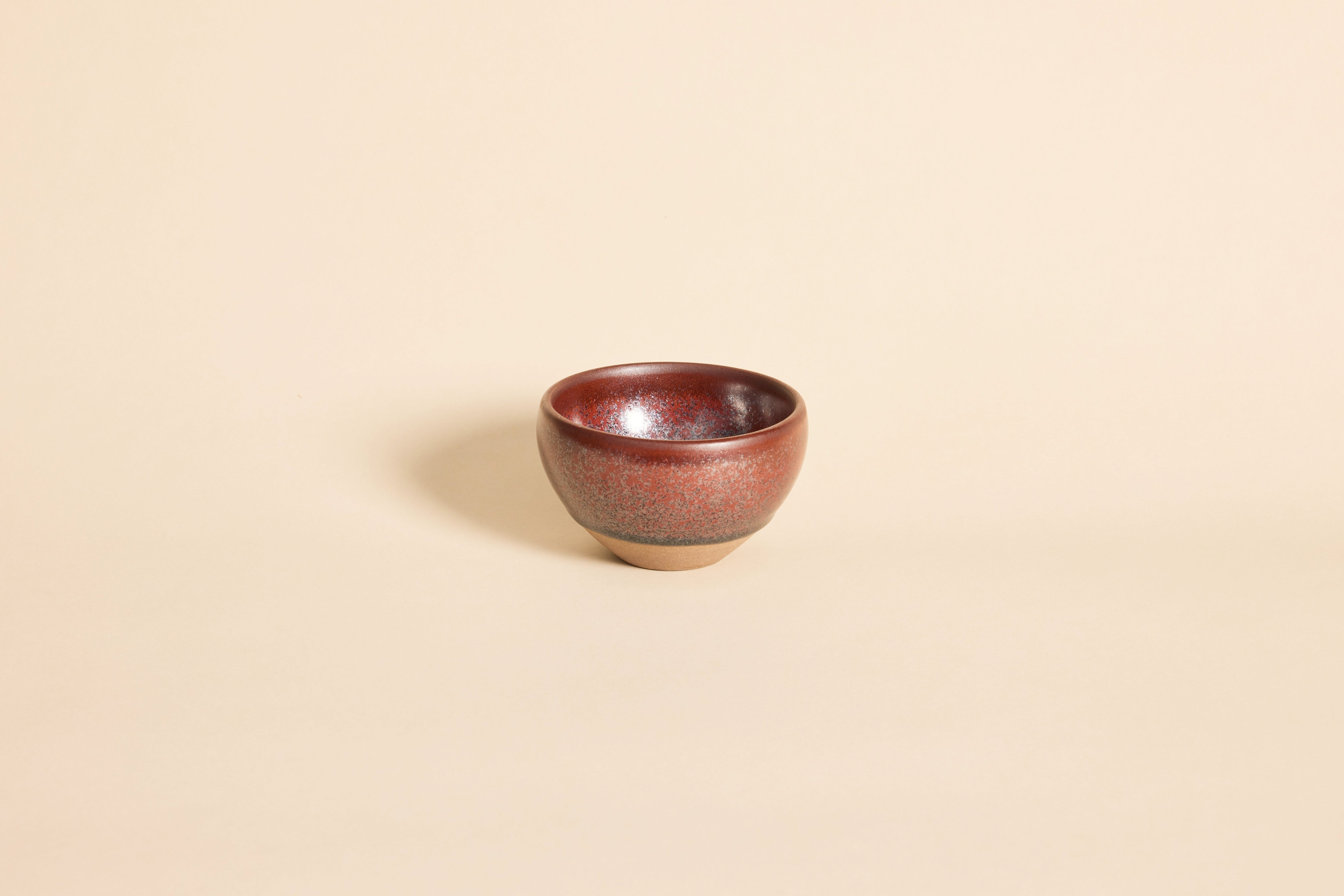 Dark red Tenmoku Jianzhan tea cup with subtle flowing ember patterns